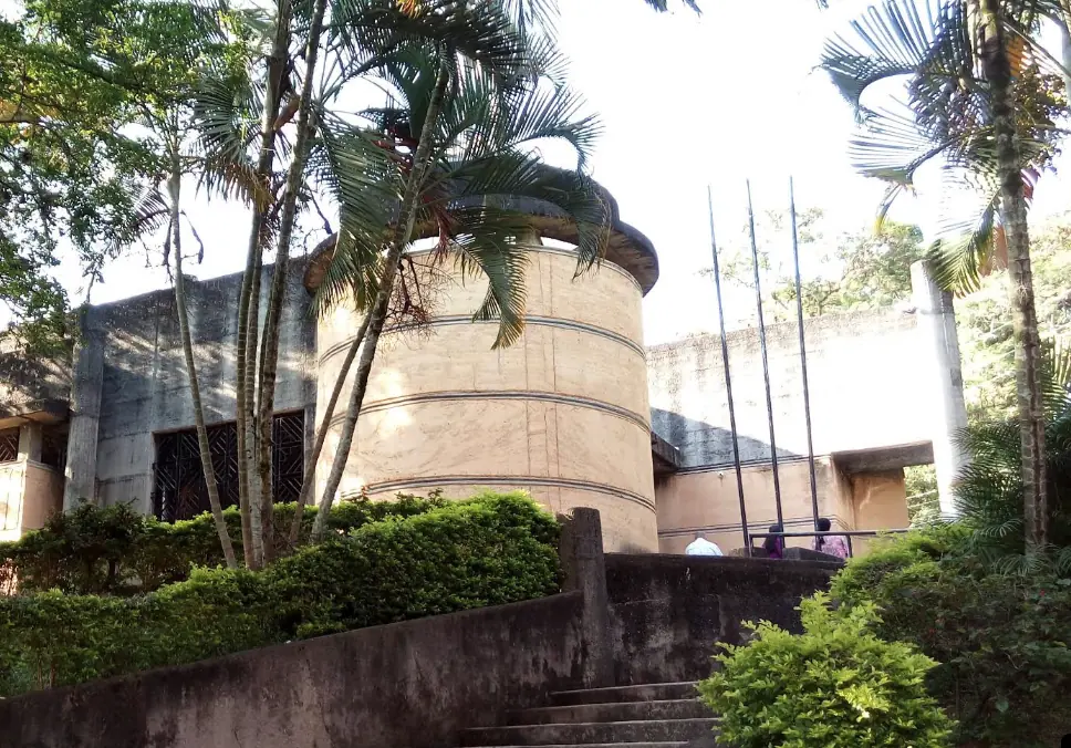 Iglesia Señor de los Cristales entre palmas, con su torre cilíndrica y escaleras de piedra